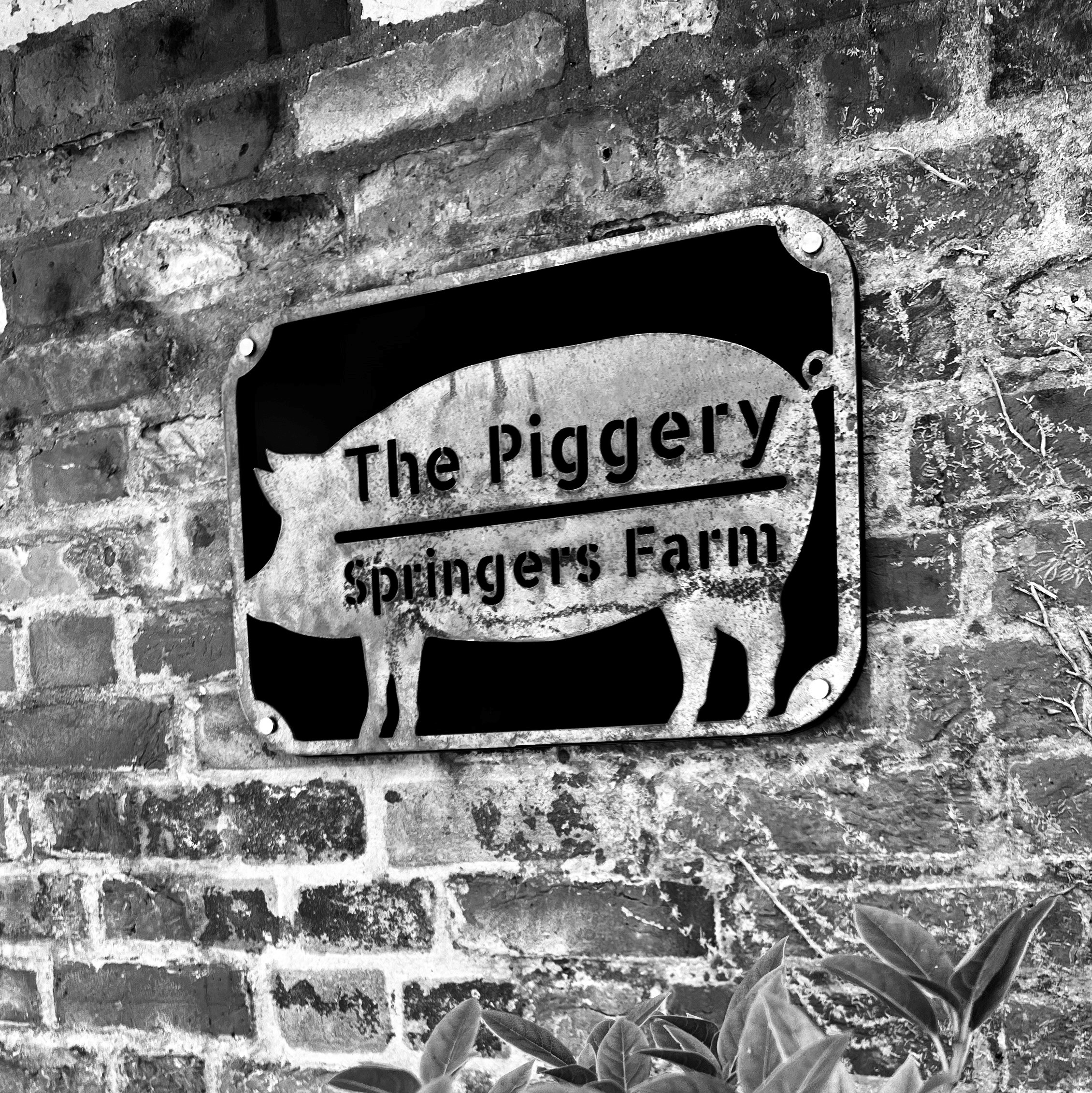 The Piggery sign at Springers Farm on a brick wall